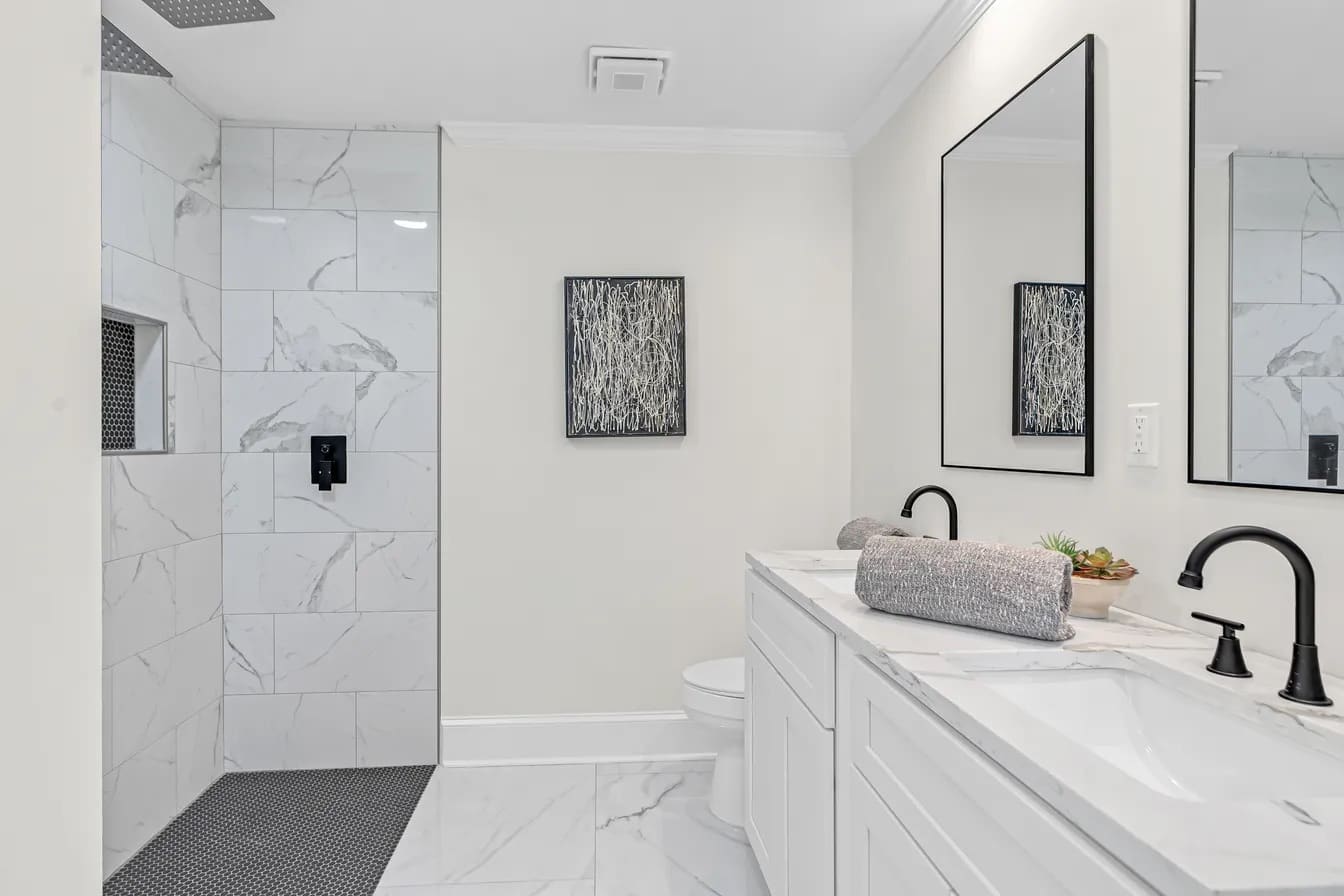 Bathroom remodel with marble-look tile shower and matte black fixtures