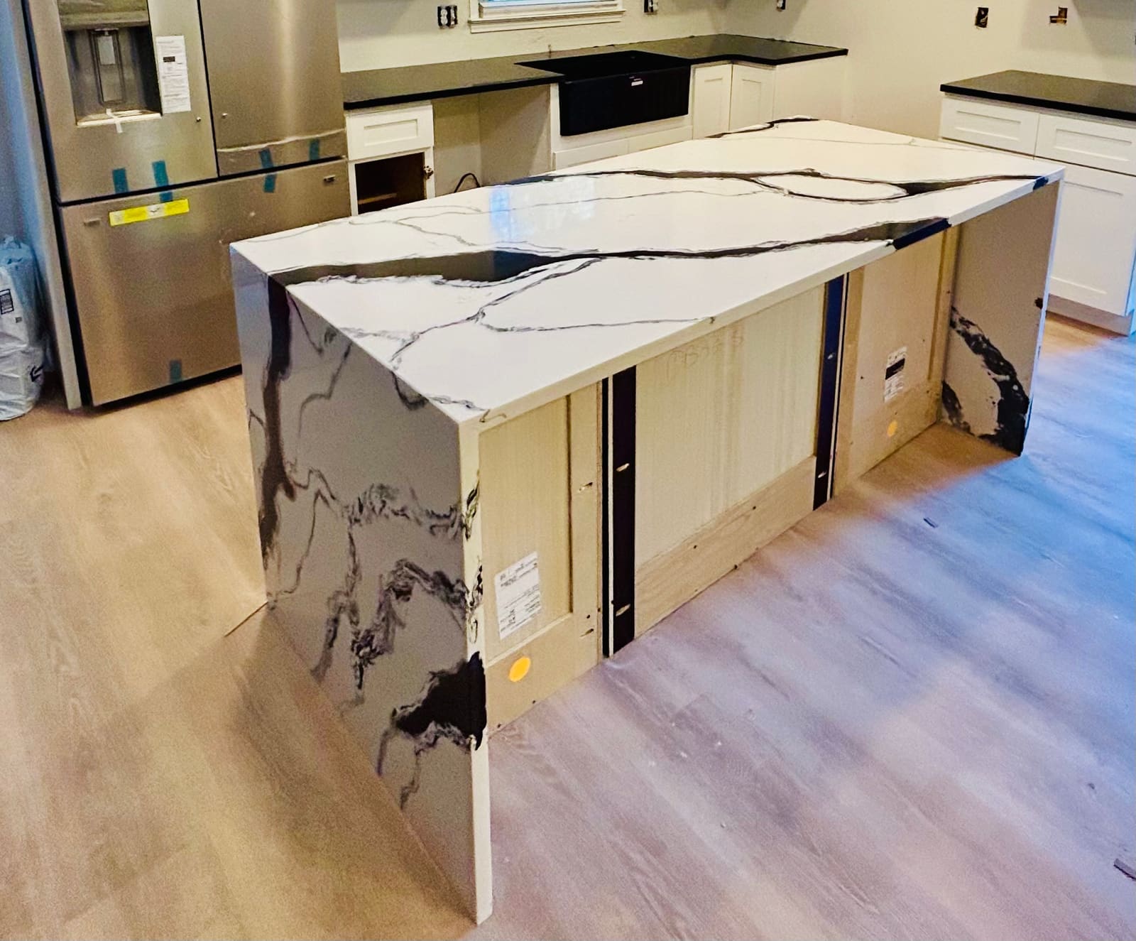 Calacatta quartz waterfall island installed on a dark wood floor